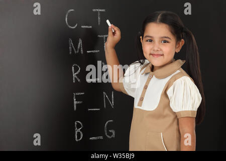 Ritratto di una studentessa che scrive su una lavagna Foto Stock