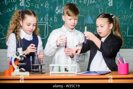 I bambini piccoli. La scienza. La scienza chimica. esperimenti di biologia con microscopio. Ragazze e ragazzi in laboratorio. I bambini a guadagnare la chimica in laboratorio scolastico. Godersi la vita degli studenti. Foto Stock