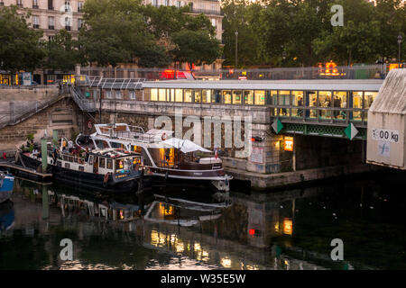 Barche e la stazione metropolitana di Bastille, Jardin du Port de l'Arsenal, parco pubblico a Canal St Martin, Parigi Francia. Foto Stock