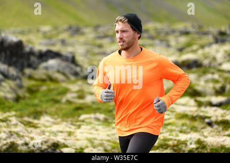 Runner. Sport con uomo che corre nel cross country trail run. Atleta maschio esercizio e formazione all'aperto nella splendida natura della montagna paesaggio. Foto Stock