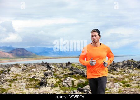 Sport con uomo che corre nel cross country trail run. Runner maschio esercizio e formazione all'aperto nella splendida natura della montagna paesaggio di Snaefellsnes, Islanda. Foto Stock