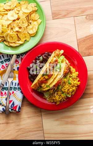 Messicano tacos di pollo con riso e piantaggine chips Foto Stock