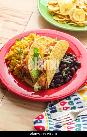 Messicano tacos di pollo con riso e piantaggine chips Foto Stock