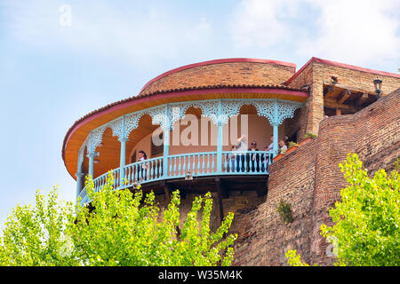 Tbilisi, Georgia - 29 Aprile 2017: persone presso il vecchio tradizionale scultura in legno balcone nella città vecchia di Tbilisi, Georgia Foto Stock