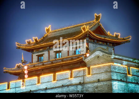 Una torre illuminata di notte sulle mura della citta' di Xian nella provincia di Shaanxi, Cina. Foto Stock