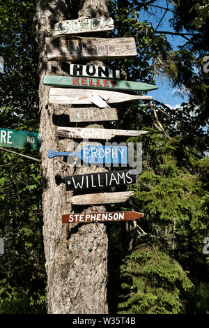 Segni fatti a mano case di marcatura mediante il nome di famiglia su un albero a cinque isole nel porto di Georgetown, Maine. Foto Stock