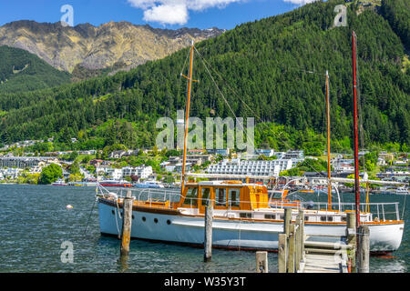 La barca di legno ormeggiata al pontile in legno sulle rive del Lago Wakatipu vicino a Queensland, Isola del Sud, Nuova Zelanda Foto Stock