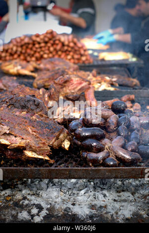 Tradizionali argentini 'asado' (barbeque). Grandi pezzi di carne e salsicce di sangue sulla griglia. Foto Stock