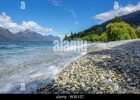 Stoney litorale del Lago Wakatipu con le montagne sullo sfondo, Queenstown, Isola del Sud della Nuova Zelanda Foto Stock