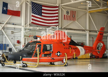 Un MH-65 Delfino elicottero siede presso il pronto a rispondere alla depressione tropicale Barry presso la guardia costiera Stazione aria Houston Luglio 11, 2019. La costa di protezione viene pre-risposta di staging dei beni nella Costa del Golfo regione grazie ad una previsione di una tempesta tropicale e possibile uragano. (U.S Coast Guard foto di Sottufficiali di terza classe Paige Hause) Foto Stock