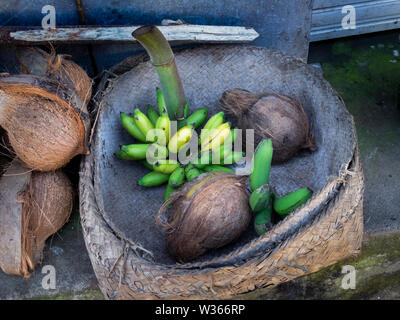 Banana e noce di cocco in un tradizionale cestello fatti a mano su un asiatico mercato degli agricoltori Foto Stock