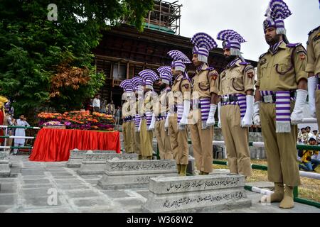 La questione del Kashmir, India. 13 Luglio, 2019. Jammu e Kashmir poliziotti omaggio accanto alle tombe al martire il cimitero a Srinagar Kashmir. 13 luglio è osservata come martiri" Giorno per rendere omaggio al 22 civili uccisi in cottura mediante esercito Dogra fuori Srinagar prigione centrale nel 1931. Credito: SOPA Immagini limitata/Alamy Live News Foto Stock