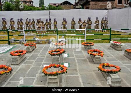 La questione del Kashmir, India. 13 Luglio, 2019. Jammu e Kashmir poliziotti omaggio accanto alle tombe al martire il cimitero a Srinagar Kashmir. 13 luglio è osservata come martiri" Giorno per rendere omaggio al 22 civili uccisi in cottura mediante esercito Dogra fuori Srinagar prigione centrale nel 1931. Credito: SOPA Immagini limitata/Alamy Live News Foto Stock