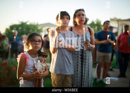 Bloomington, Stati Uniti d'America. 12 Luglio, 2019. I dimostranti si riuniscono per le luci per la libertà: una veglia al fine umano nei campi di detenzione di rally e fiaccolata sui gradini della Contea di Monroe Courthouse in Bloomington. Presidente USA Trump dice ICE sarà condotta incursioni contro gli immigrati clandestini in città americane nel corso del fine settimana. Credito: SOPA Immagini limitata/Alamy Live News Foto Stock