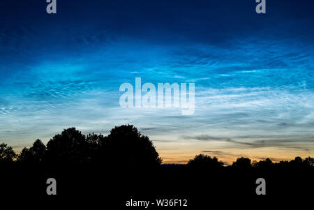 Rare le nuvole Noctilucent noto anche come argento nuvole nel cielo notturno in un paesaggio rurale al di fuori della citta'. Questi fenomeni sono costituiti da nuvole di ghiaccio cryst Foto Stock