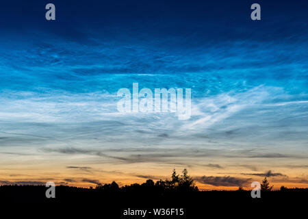 Rare le nuvole Noctilucent noto anche come argento nuvole nel cielo notturno in un paesaggio rurale al di fuori della citta'. Questi fenomeni sono costituiti da nuvole di ghiaccio cryst Foto Stock