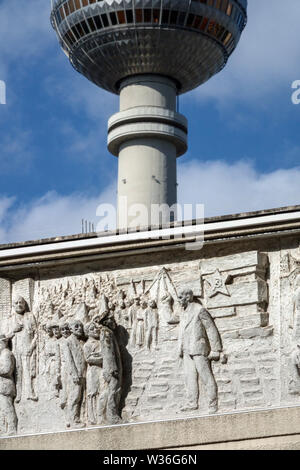 Rilievo sulla costruzione del periodo comunista della Germania orientale Berlino torre della TV, Alexanderplatz con i simboli di una stella, falce, arte del comunismo del martello Foto Stock