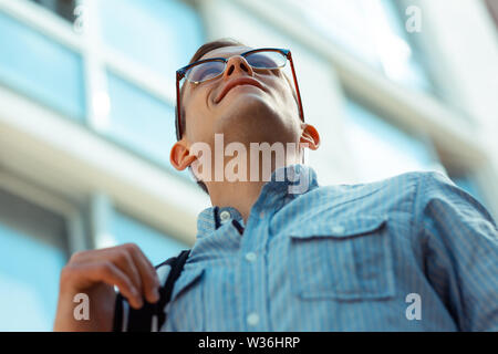 Ravvicinata di un uomo che indossa gli occhiali a piedi per l'ufficio Foto Stock