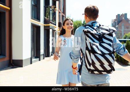 Bella ragazza sorridente mentre si cammina per il suo uomo Foto Stock