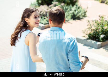 Curly ragazza ridere mentre si parla con il suo uomo Foto Stock