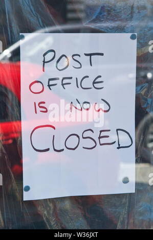 Ufficio postale chiuso segno sulla finestra del negozio nel centro della città a Builth Wells Powys Wales UK Foto Stock
