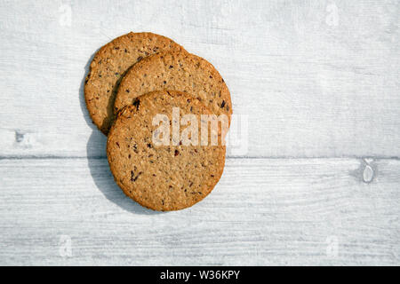 Senza glutine Oatcake fatta con flaxseeds e uvetta - adatto per vegani. Isolato su un rustico tavolo. Foto Stock
