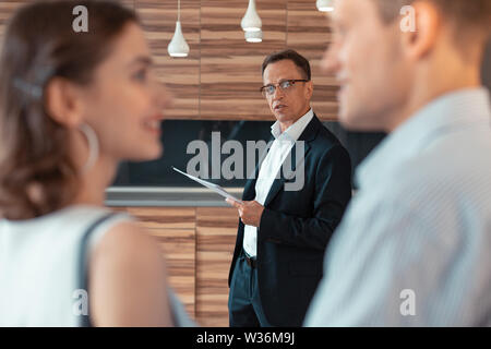 Agente immobiliare che parla al giovane dicendo circa house Foto Stock