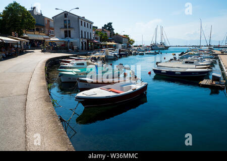 Barche ormeggiate al molo presso la piccola marina a Malinska sull'isola di Krk in Croazia Foto Stock