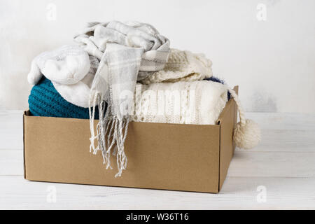 Abbigliamento invernale in una scatola di cartone. Abbigliamento stagionale per la spedizione o la donazione. Foto Stock