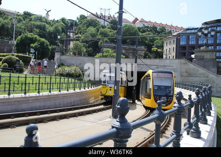 Due treni di tram che passa ogni altro uscente da un tunnel a Budapest Foto Stock