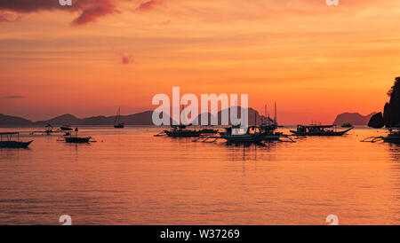 Bel tramonto con sagome di barche filippina in El Nido, isola di Palawan, Filippine Foto Stock