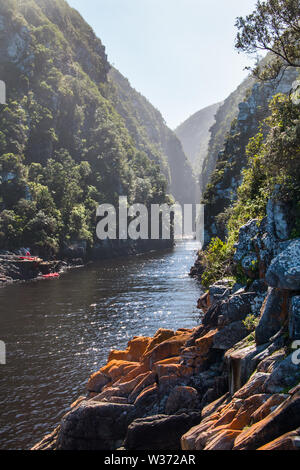 Deep river gorge natura paesaggio con un gruppo di persone su canoe nel lontano sullo sfondo. Foto Stock