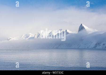 Incredibile tramonto su montagna e fiordo, paesaggio invernale, Norvegia il sole tramonta sulle Alpi norvegesi e l'ora blu inizia nel raggio di azione a Senja, Norvegia Foto Stock