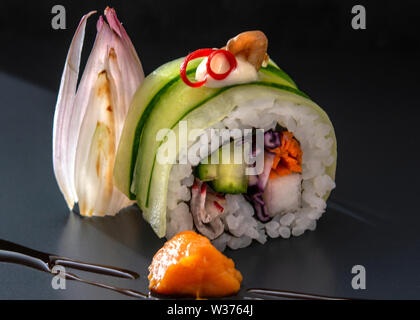 Il sushi e il sashimi rotoli maki nigiri e da dentro a fuori rotoli maki artisticamente disposte con ingredienti regionali Foto Stock