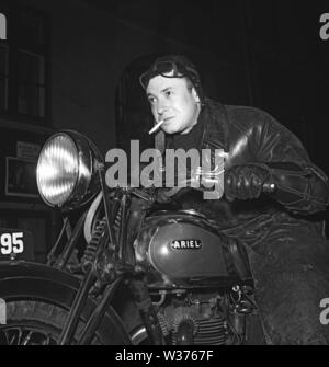 Motociclista nel 1940s. Un giovane uomo che indossa occhiali e un cappuccio in pelle dalla sua moto. Il motociclo è un cittadino britannico di Ariel. La Svezia 1946. Kristoffersson ref T49-3 Foto Stock