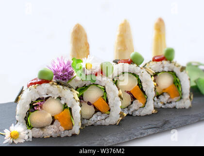 Il sushi e il sashimi rotoli maki nigiri e da dentro a fuori rotoli maki artisticamente disposte con ingredienti regionali Foto Stock