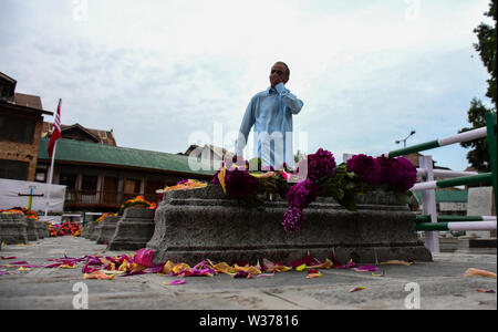 Srinagar Kashmir. Il 13 luglio 2019. 13 Luglio, 2019. Flusso principale i membri del partito e della gente del posto fiori laici sulle tombe a "martiri cimitero'' a Srinagar, in indiano Kashmir amministrato. Il 13 luglio è osservata come martiri" Giorno nel Kashmir per rendere omaggio al 22 civili uccisi dall'esercito Dogra fuori Srinagar prigione centrale nel 1931. Le restrizioni sono state poste in tutta la valle di contrastare qualsiasi protesta e al bar la Pro-Freedom camp da visitare il cimitero Credito: Muzamil Mattoo/IMAGESLIVE/ZUMA filo/Alamy Live News Foto Stock