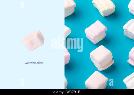 Layout creativo fatto di dolci marshmallows su sfondo blu. Il minimalismo concept Foto Stock