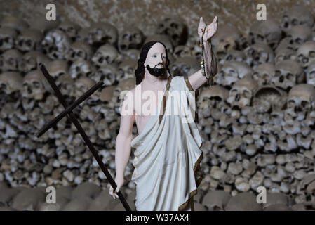 Statua di Gesù di fronte alle vittime di teschi dalla peste del 1656 e di una epidemia di colera nel 1836, Cimitero delle Fontanelle, Napoli, Italia, Europa. Foto Stock