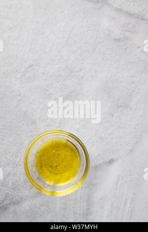 Olio di oliva in vaso di vetro isolato sulla superficie di pietra Foto Stock