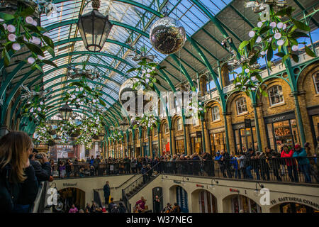 Il Covent Garden a tempo di Natale splendide decorazioni e tetto ad arco del vecchio mercato, Londra Foto Stock