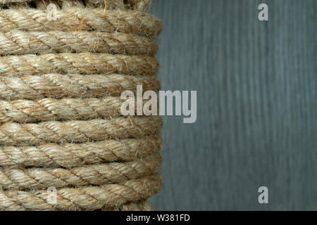 Twisted tela ruvida di iuta di corda di spago in close-up sul grigio sfondo rustico Foto Stock