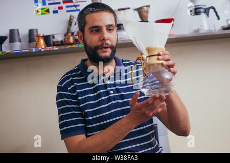 La produzione di birra nel caffè antigoccia. passo per passo le istruzioni di cottura. Barista versando preparato del caffè in tazza Foto Stock