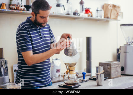 La produzione di birra nel caffè antigoccia. passo per passo le istruzioni di cottura. Barista versando preparato del caffè in tazza Foto Stock