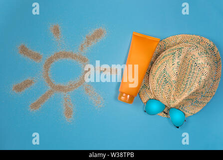 Dipinto di sun, cappello, crema solare e occhiali da sole su sfondo blu. Vista dall'alto. Tema la spiaggia su sfondo blu. Foto Stock