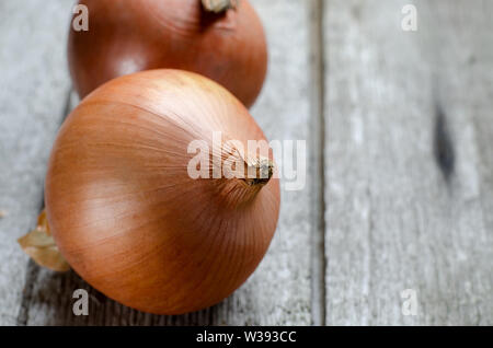 Mature cipolla dorata su un vintage in legno rustico board. Foto Stock
