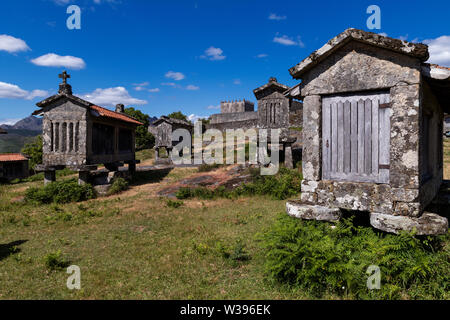 Vista dei granai (espigueiros) e castello medievale nel villaggio storico di Lindoso, Portogallo. Foto Stock