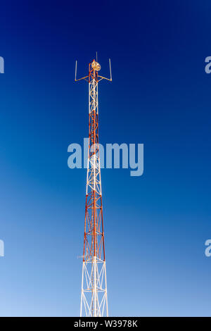 Il bianco e il rosso telefono cellulare torre cellulare ripetitore, con un piccolo forno a microonde piatto. Foto Stock