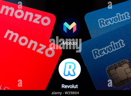 Foto macro di Monzo e Revolut carte bancarie sullo schermo dello smartphone accanto alle loro applicazioni. Foto concettuale per evidenziare la concorrenza. Foto Stock