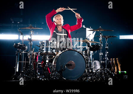 Dominic Howard, il batterista della band inglese Muse, esecuzione dal vivo sul palco a Milano, presso lo Stadio di San Siro per la "Teoria di simulazione" tour Foto Stock